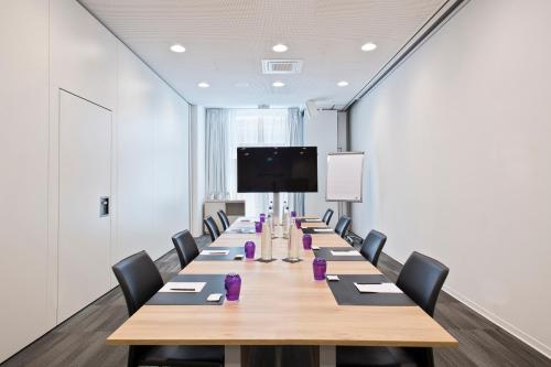 a long conference room with a long table and chairs at INNSiDE by Meliá Leipzig in Leipzig