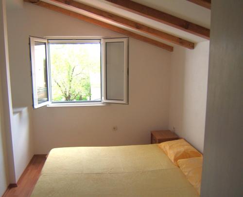 a bedroom with a bed and a window at Apartmani Stipanelo in Murter
