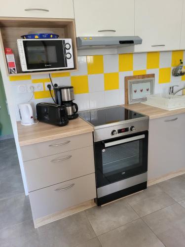 une cuisine avec une cuisinière et un micro-ondes dans l'établissement Gite et Tiny de La Terrière -Dordogne en Périgord, à La Chapelle-Aubareil