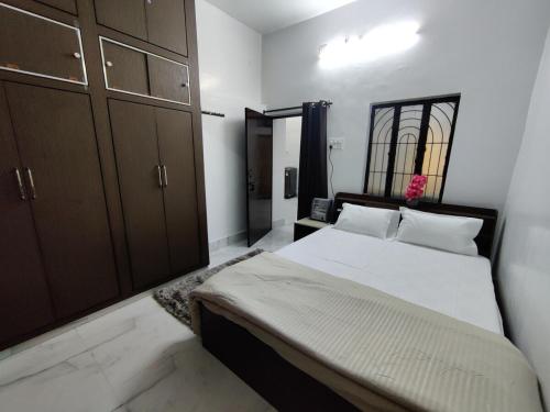 a bedroom with a large bed with brown cabinets at Prayag Prasadam in Allahābād