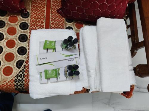 a table topped with white towels and green accents at Prayag Prasadam in Allahābād