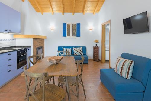 a living room with a table and a blue couch at Herdade Vale de Gaios in Odemira