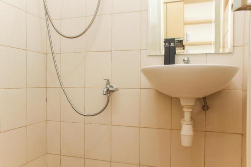 a bathroom with a sink and a shower at Simple and Comfort Studio at Riverview Jababeka Apartment By Travelio in Cikarang