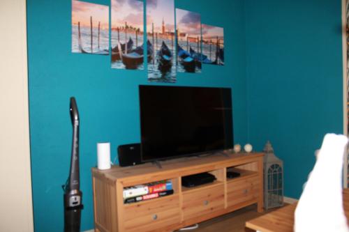 a living room with a television on a wooden entertainment center at Ca’Benvenuto in Doische