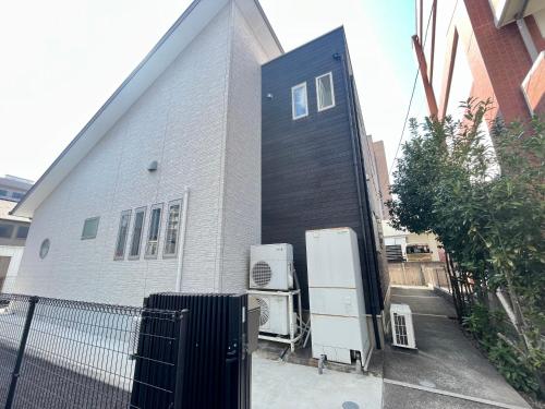 a house with a black door and two refrigerators at U&T House in Beppu