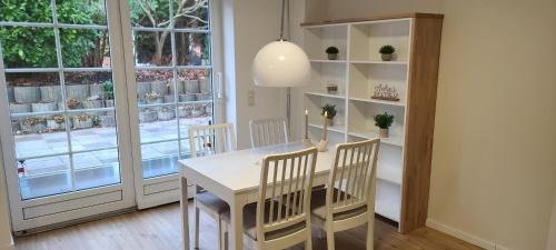 a dining room with a table and chairs and a window at Strandhygge in Flensburg