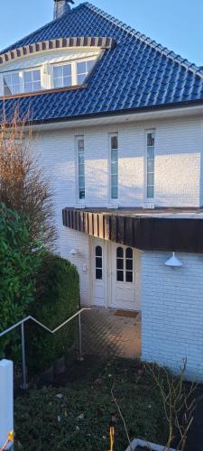 a large white house with a solar roof at Strandhygge in Flensburg