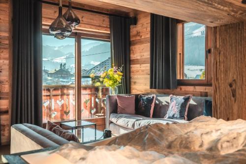 un salon avec un canapé et une grande fenêtre dans l'établissement Chalet Kerasia Morzine - by EMERALD STAY, à Morzine