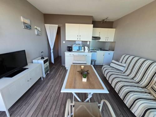 un salon avec un canapé et une table dans l'établissement Joli studio face mer et estacade, à Saint-Jean-de-Monts