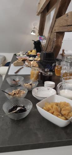 einen Tisch mit Teller mit Lebensmitteln auf einer Theke in der Unterkunft Au Lampadaire Briarois in Briare