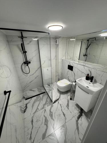 a white bathroom with a sink and a toilet at Moft Hotel Apartments Free Parking Self Check-In in Oradea