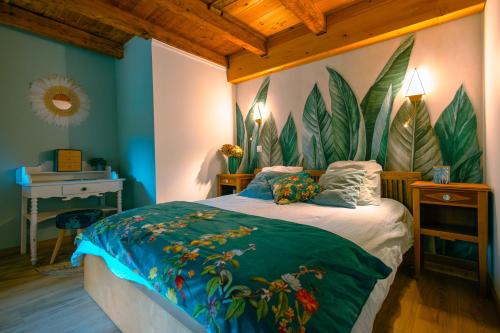 a bedroom with a bed with leaves painted on the wall at La grange de l'Adour - Trassouet in Campan