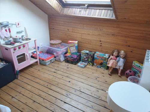 Deux poupées se tiennent dans une pièce avec des cadeaux dans l'établissement Entire home - Centre Fécamp - 14 Mathilda, à Fécamp