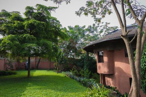 a house in a yard with trees and grass at Trois Ore Residences & Green Earth Bistro in Ibadan