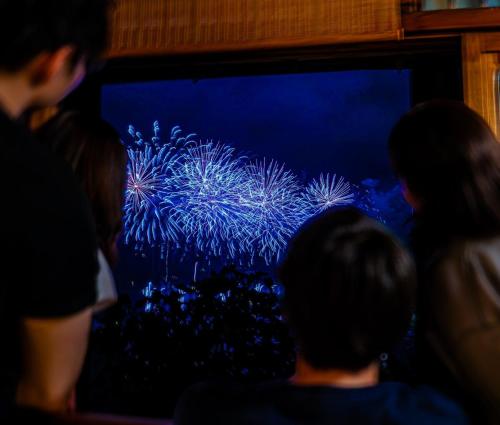 a group of people looking at a display of fireworks at Suite Villa Curation Atami Sutosuien in Atami