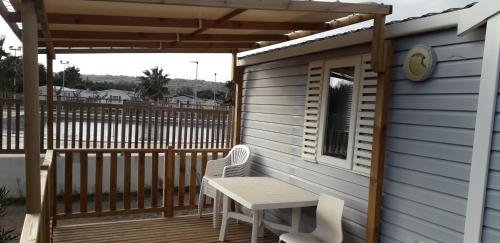 un patio avec une table et des chaises sur une terrasse dans l'établissement omer novela, à Port-la-Nouvelle