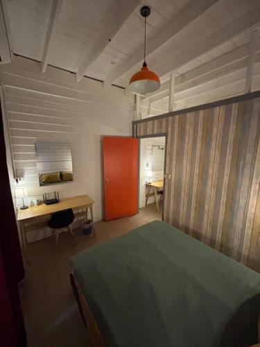 a bedroom with a bed and a desk and a red door at La Locanda in Bangkok