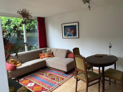 a living room with a couch and a table at The green house in Groesbeek