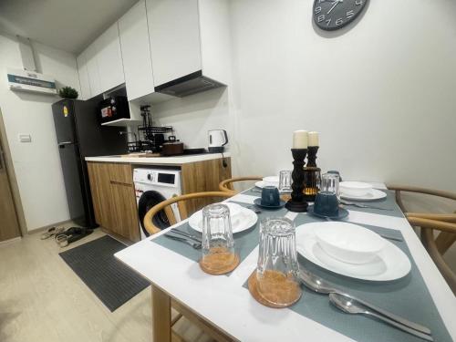 a kitchen with a table with plates and glasses on it at Ekamai 2 bed room in Khlong Toei