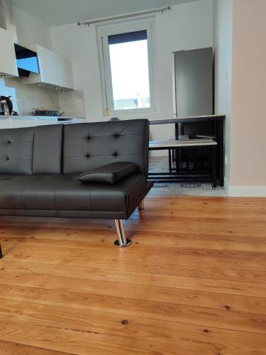 - un canapé noir dans le salon avec une table dans l'établissement Entire home - Centre Fécamp - 36 Elena, à Fécamp