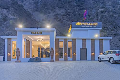 a white car parked in front of a building at Echor Palm Bliss Riverside Resort & Spa Kasol in Kasol