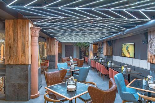 a restaurant with wooden ceilings and tables and chairs at Echor Palm Bliss Riverside Resort & Spa Kasol in Kasol