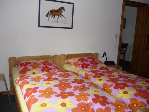 a bedroom with two beds and a picture of a horse at Hof Loestrup - Ferienwohnungen inmitten der wunderschönen Landschaft Angeln in Sörup