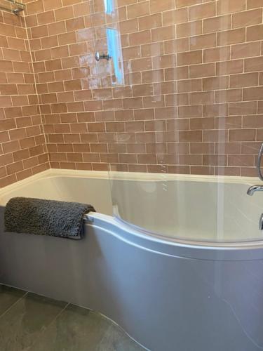 a bathroom with a bath tub with a towel on it at Picton House: Charming 3 bed property in quiet location in Ramsgate