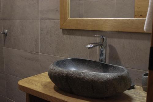 a bathroom with a stone sink and a mirror at Eko hiša-Eco House Na razpotju in Solčava