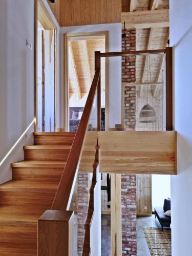 a staircase in a house with a brick wall at Czôrny Dąb - nowoczesny dom wakacyjny na Kaszubach, jacuzzi, sauna, bilard in Garcz