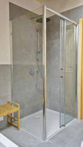 a shower with a glass door in a bathroom at Czôrny Dąb - nowoczesny dom wakacyjny na Kaszubach, jacuzzi, sauna, bilard in Garcz