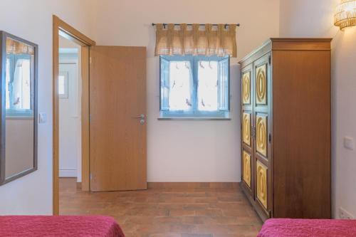 a bedroom with a bed and a window and a dresser at Herdade Vale de Gaios in Odemira