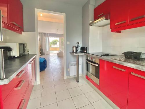 une cuisine avec des placards rouges et un comptoir rouge dans l'établissement Lou Paradou Classé 3 etoiles plage à 3mn à pieds parking ByLaConciergerie13, à La Ciotat