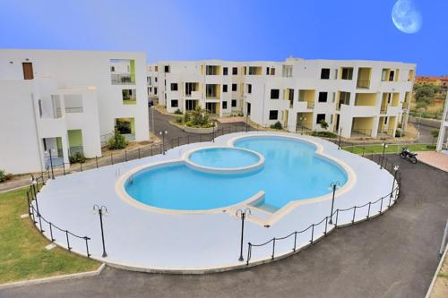 a large swimming pool in front of some apartment buildings at San Rocco One Bed Apartments 1B3 3 in Isca sullo Ionio