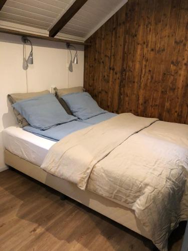 a large bed in a room with wooden walls at Waterjuffer in Noordlaren