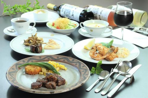 a table with plates of food and cups of wine at Pension J-HOUSE in Kiso
