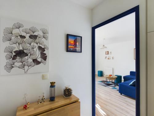 un salon avec un canapé bleu et un miroir dans l'établissement -INDIGO-T3 avec balcon et 2 places de parking, à Concarneau