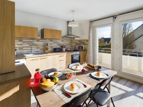 - une cuisine avec une table et des fruits dans l'établissement -INDIGO-T3 avec balcon et 2 places de parking, à Concarneau