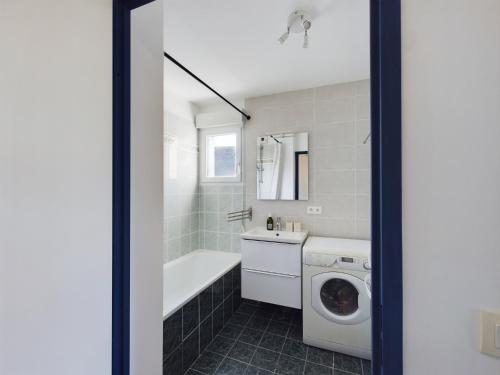 une salle de bain avec un lavabo et une machine à laver dans l'établissement -INDIGO-T3 avec balcon et 2 places de parking, à Concarneau