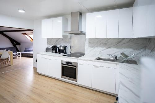 une cuisine blanche avec un évier et une cuisinière dans l'établissement Apartment Hyper Centre Fécamp 21 Bianca, à Fécamp