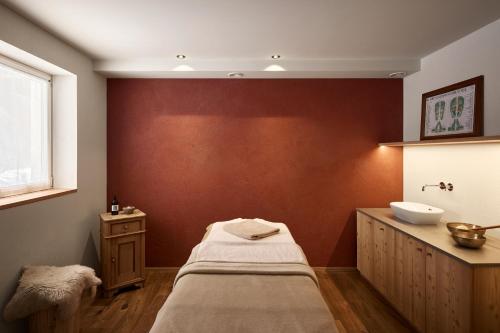 a bathroom with a bed and a sink at Hotel Bella Vista in Trafoi