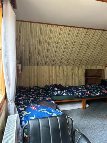 a bedroom with a bed and a wooden wall at Chata KOZLOV in Střelské Hoštice