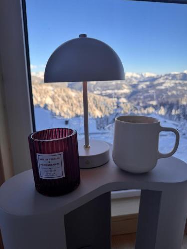 a desk with two coffee cups and a lamp on it at Stubihuettn in Sonnenalpe Nassfeld