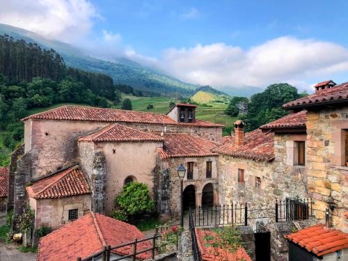 a group of stone buildings with red tile roofs at El Molino de Leyte - Charming Riverside Cottage in Carmona, Cantabria in Carmona