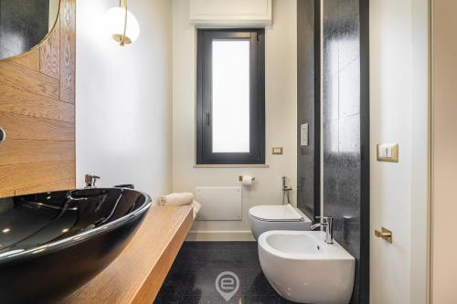 a bathroom with a black tub and a toilet and a sink at Biora Hospitality in Serri
