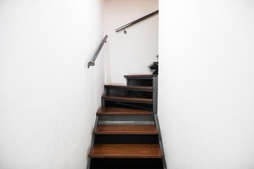 a staircase in a house with white walls and wooden floors at Domoruja B&B in Sassari