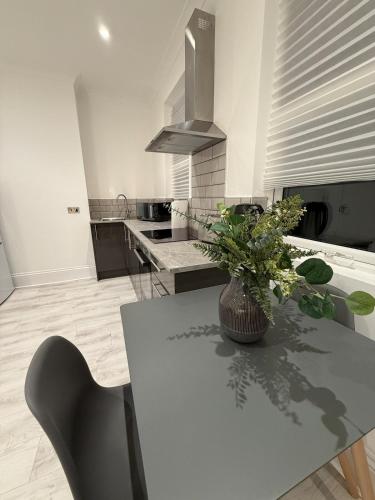 a kitchen with a table with a potted plant on it at The Avenue Suite in London