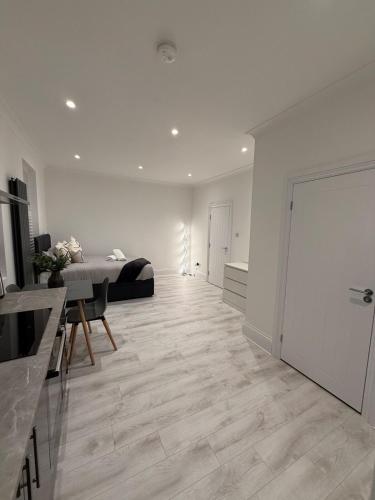 a large white room with a bed and a table at The Avenue Suite in London