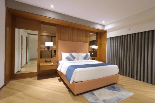 a bedroom with a king sized bed in a room at Ramada Encore by Wyndham Viramgam in Viramgām