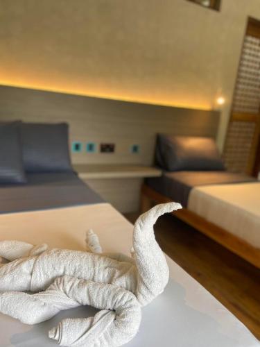 a towel animal sitting on a bed in a room at Angeles Hut Fishermans Wharf in Laguindingan
